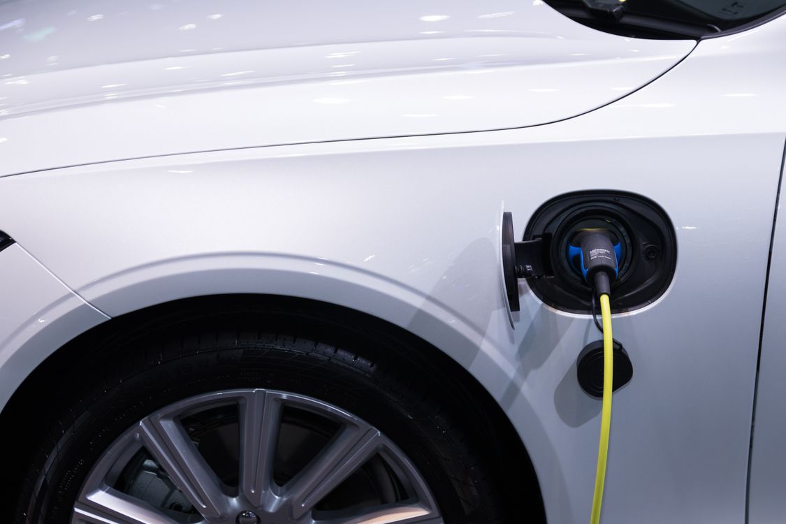 An electric vehicle connected to a charging cable, contextual photograph